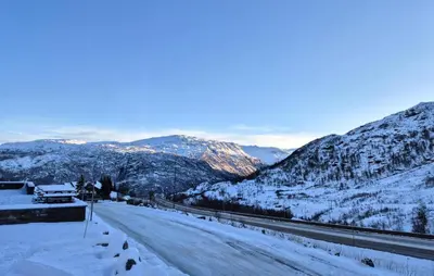 a road covered in snow with mountains in the background at 2 Bedroom Cozy Apartment In Røldal in Røldal