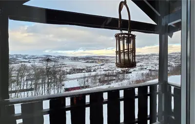 a chandelier hanging from a window looking out at a snow covered field at Nice Home In Rauland With Wifi in Rauland