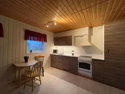 a kitchen with a table and a stove top oven at Leilighet i paradisbukta in Torvikbukt