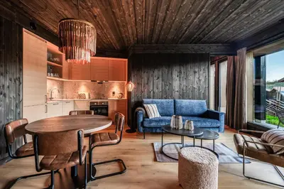 a living room with a blue couch and a table at Kikut Alpin Lodge 2102 in Hol