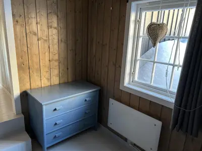 a room with a blue dresser and a window at Mountain cabin in Lillehammer in Lillehammer