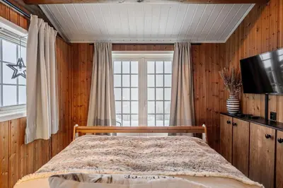 a bedroom with a bed and a tv and a window at Trysilfjell hytteomrade 589 in Hovi
