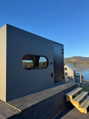 a door on the side of a building with a window at Langelandsvik Gard Birdbox