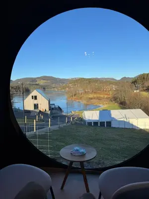 a round window with a view of a body of water at Langelandsvik Gard Birdbox