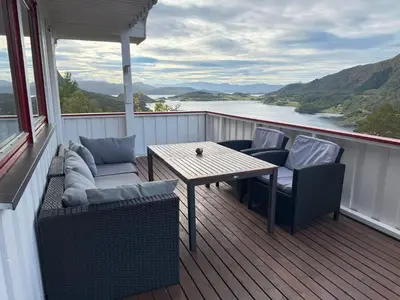 a deck with a table and chairs on a balcony at Holiday Home Stabben white House by Interhome in Aure