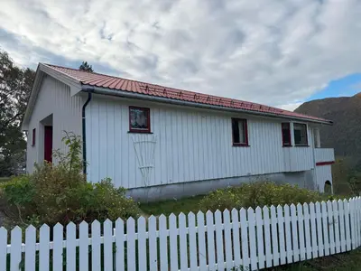 a small white house with a white fence at Holiday Home Stabben white House by Interhome in Aure