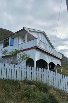 a white house behind a white picket fence at Holiday Home Stabben white House by Interhome in Aure