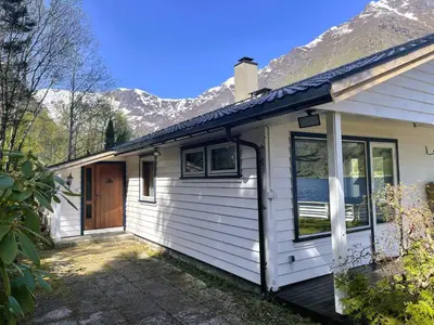 a white house with mountains in the background at Holiday Home Fjordtraum by Interhome in Balestrand