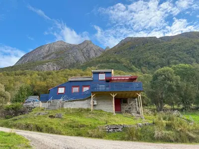 a blue house on a hill with mountains in the background at Holiday Home Stabben Blue House by Interhome in Storsæter