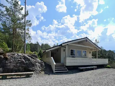 a tiny house with a porch and a rock at Holiday Home mit Blick auf das Wasser by Interhome in Hebnes
