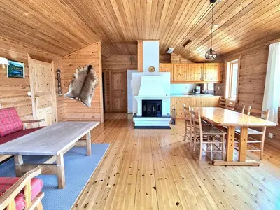 a kitchen with a table and a stove in a cabin at Holiday Home mit Blick auf das Wasser by Interhome in Hebnes