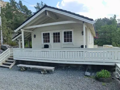 a small white house with a porch and a ramp at Holiday Home mit Blick auf das Wasser by Interhome in Hebnes