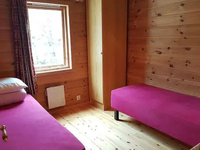 a bedroom with a pink bed and a window at Holiday Home mit Blick auf das Wasser by Interhome in Hebnes