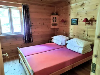 a bedroom with a bed in a wooden room at Holiday Home Ein Traumstandort by Interhome in Hebnes