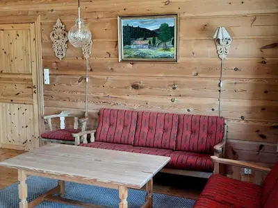 a living room with a red couch and a table at Holiday Home Ein Traumstandort by Interhome in Hebnes