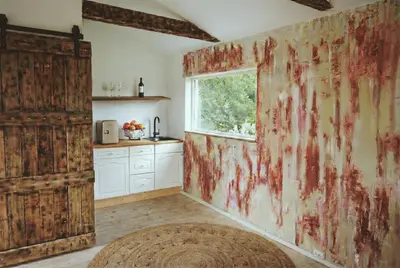 a kitchen with a wall covered in red paint at Romantic Getaway Hot Tub, Cinema & View in Stange