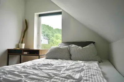 a bedroom with a bed and a window at Modern 3-bedroom apartment with a view in Trondheim