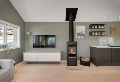 a living room with a fireplace and a tv at Exclusive mountain cabin - Panoramic views in Vossevangen