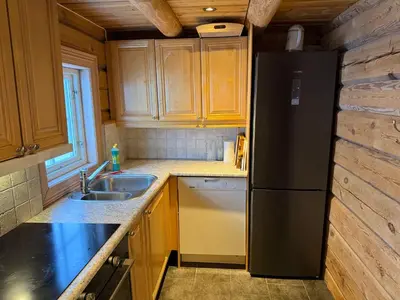 a kitchen with a black refrigerator and a sink at Cabin at Fageråsen - 4 roomed family cabin for skiing in Trysil in Trysil