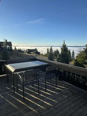 two benches sitting on top of a deck with a table at Exclusive family cabin in Hafjell ski-in-ski-out in Hafjell