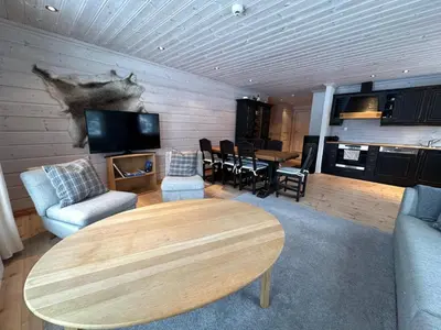 a living room with a table and a tv at Botn Fjellstue in Botn