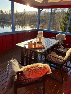 a table and chairs on the deck of a boat at Magic Cabin by Lake & Forest , Peace, Views & Outdoor Fun, in Opphus