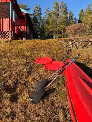 two red canoes sitting in the grass next to a house at Magic Cabin by Lake & Forest , Peace, Views & Outdoor Fun, in Opphus