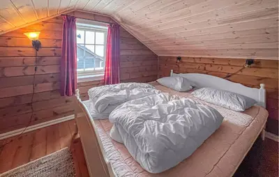 two beds in a log cabin with a window at Awesome Home In Gålå With Sauna in Gålå