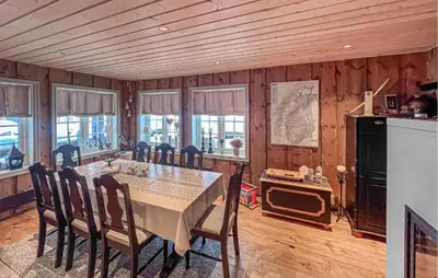 a dining room with a table and chairs and windows at Awesome Home In Gålå With Sauna in Gålå