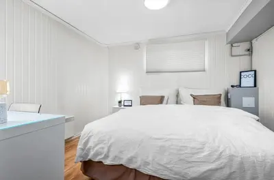 a white bedroom with a large white bed in it at Spacious 3 Bedroom Basement Apartment with Parking, Close to Trondheim City Center in Trondheim