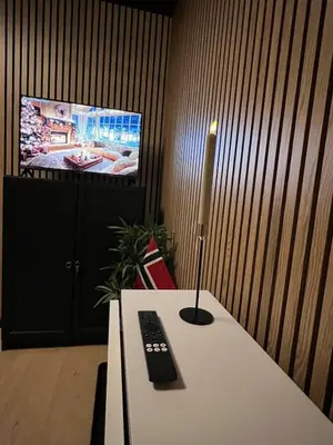 a candle on a table in front of a tv at Central Bergen Stay for Families & Groups-6 Guests in Bergen