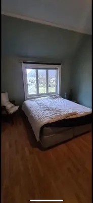 a bedroom with a large bed with a window at Central Stay Odda in Odda