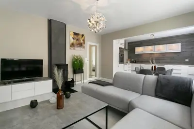a living room with a couch and a television at Centrum apartment 2 in Ålesund
