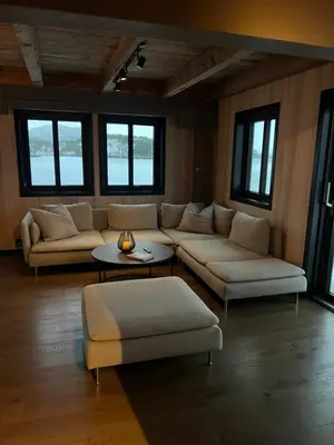 a living room with couches and tables and windows at Amundøya Seaside in Kristiansund