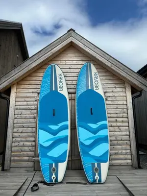 two blue surfboards are parked in front of a house at Amundøya Seaside in Kristiansund