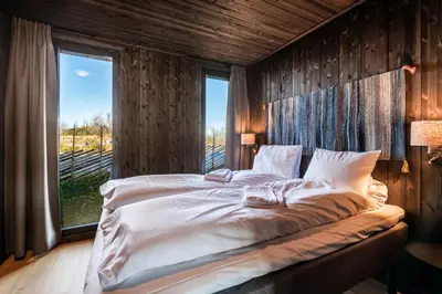 a large bed in a room with a window at Kikut Alpin Lodge 2204 in Hol