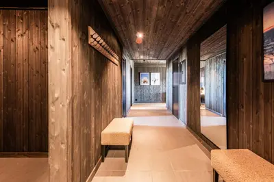 a hallway with wood paneling and a bench and a wall at Kikut Alpin Lodge 2204 in Hol