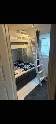 a bunk bed in a room with a ladder at Koselig bolig med stor stue, 10 min from Solsiden! in Trondheim