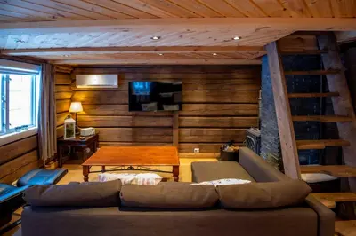a living room with a couch and a wooden wall at Trysilfjellet Sør 802 Anex in Trysil