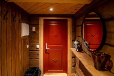 a wooden room with a red door and a mirror at Trysilfjellet Sør 802 Anex in Trysil