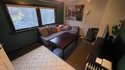 a living room with a couch and a table at Bedroom with private living room in Bergen