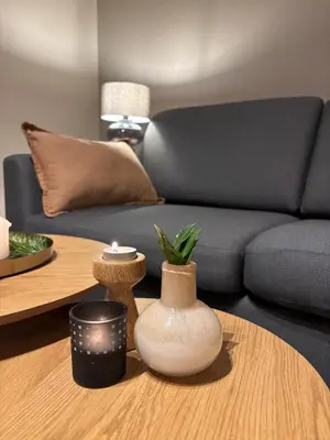 a living room with a couch and a table with vases at Midt i Raufoss, stor leilighet med hage in Raufoss