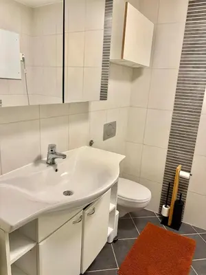 a white bathroom with a sink and a toilet at 2 bedroom apartment historical downtown by the sea in Ålesund