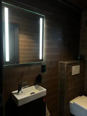 a bathroom with a sink and a mirror and a toilet at Reno Hytta in Eggedal