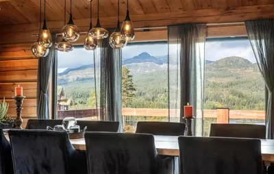 a dining room with a table and a large window at 5 Bedroom Beautiful Home In Tuddal in Tuddal