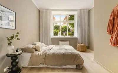 a bedroom with a bed and a window at Moderne leilighet med sjøgløtt og balkong in Bergen