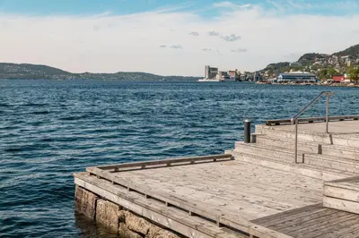 a dock on a large body of water at Moderne leilighet med sjøgløtt og balkong in Bergen