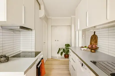a kitchen with white cabinets and a counter top at Moderne leilighet med sjøgløtt og balkong in Bergen