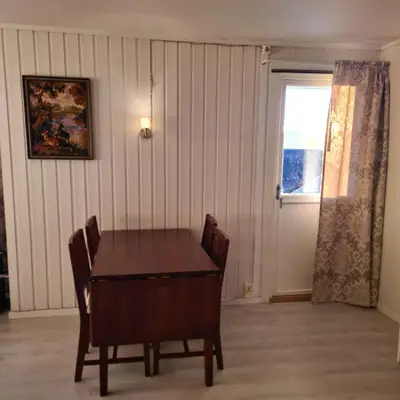 a dining room with a table and a window at Solbakken, nice Apartment by the Sea in Ålesund in Ålesund
