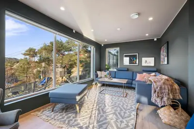 a living room with blue furniture and a large window at Luxury Seafront Villa with Panoramic Views in Veland